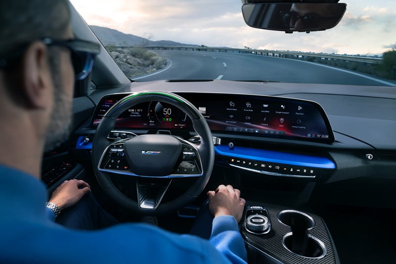 Front View of the 2026 OPTIQ-V Driving Through the Dusk Utilizing its Headlights | Brotherton Cadillac NW in SHORELINE WA